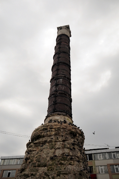 DSC_4331_1.jpg - Konstantinův sloup (Spálený sloup, Çemberlitas). Sloup byl postaven roku 330 z kvádrů Apollónova chrámu v Římě a umístěn na Konstantinovo fórum a je tak nejstarší památkou v Istanbulu. Sloup byl vysoký 50 metrů, na jeho vrcholu stála bronzová socha císaře Konstantina Velikého jako boha Apollóna. Do základů sloupu byly údajně uloženy zbytky chleba ze svatební hostiny v Káně Galilejské, posvátná soška Pallas Athény z Tróje a další relikvie, které měly místu získat přízeň bohů.Roku 1105 do sloupu uhodil blesk a zničil jeho horní část, zbytek byl ožehnut - odtud název "spálený sloup". Díky častým zemětřesením sloup popraskal. Proto byl stažen železnými obručemi a odtud se odvozuje turecký název Çemberlitas = sloup s obručemi.Dnes je sloup vysoký 37 metrů.