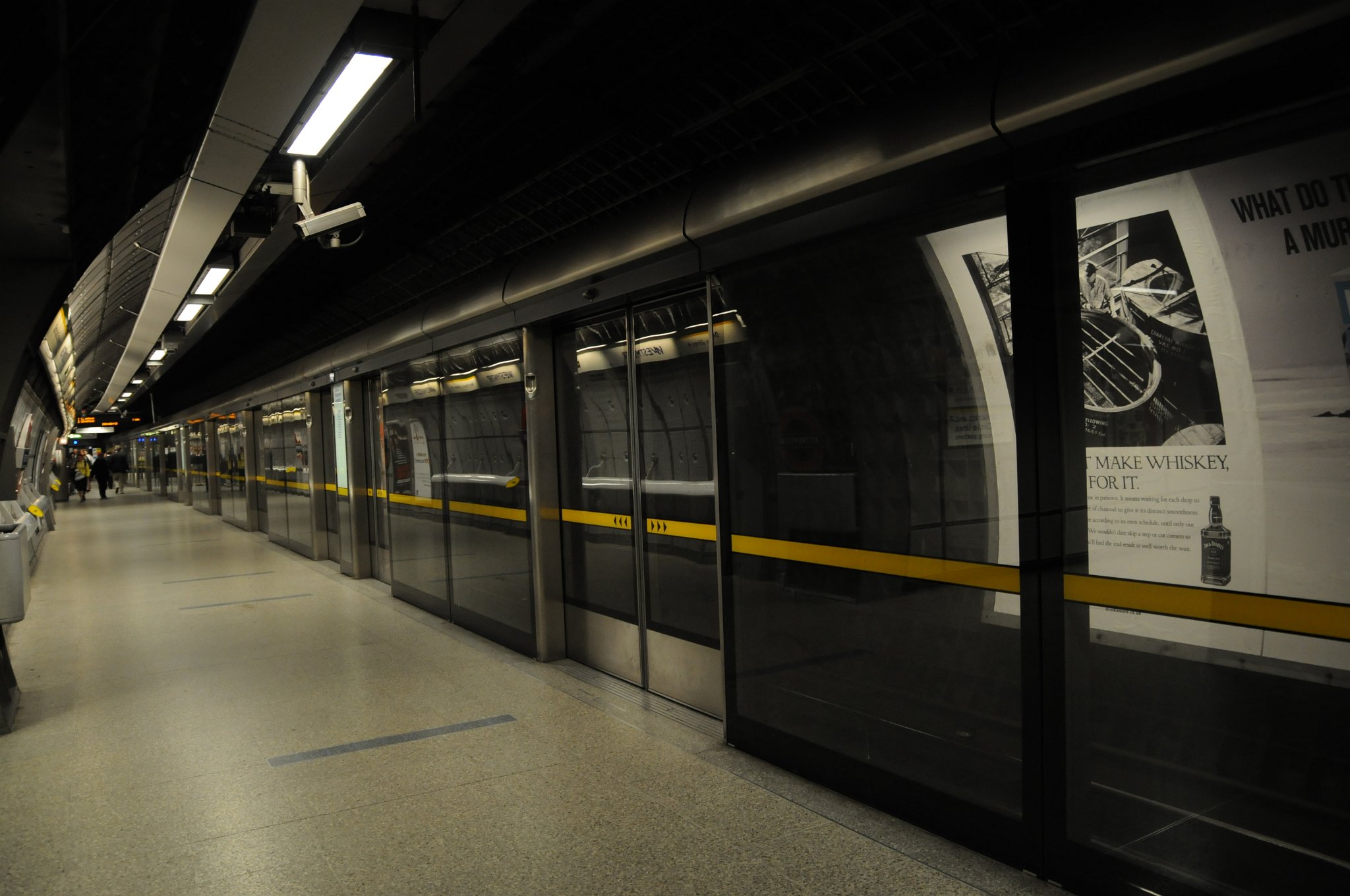 DSC_3393.JPG - Nástupiště Jubilee Line na stanici metra Westminster. Tato stanice obsluhuje tři různé linky. Stanice byla otevřena pod názvem „Westminster Bridge“ 24. prosince 1868 jako součást Metropolitan District Railway (dnešní Circle a District Line). Svůj současný název, „Westminster“, získala v roce 1907.  Mimo jiné se ve stanici nacházejí skleněné zábrany mezi nástupišťem a kolejnicemi, ty byly instalovány v souladu se snahou kontrolovat cirkulaci vzduchu ve stanici a taktéž pro zvýšení bezpečnosti cestujících. Nástupiště se nacházejí v hloubce 32 metrů; jsou jedny z nejhlouběji položených v celé síti londýnského metra. Kvůli omezenému prostoru se i nástupiště Jubilee Line nacházejí nad sebou a ne vedle sebe, jak je obvyklé.