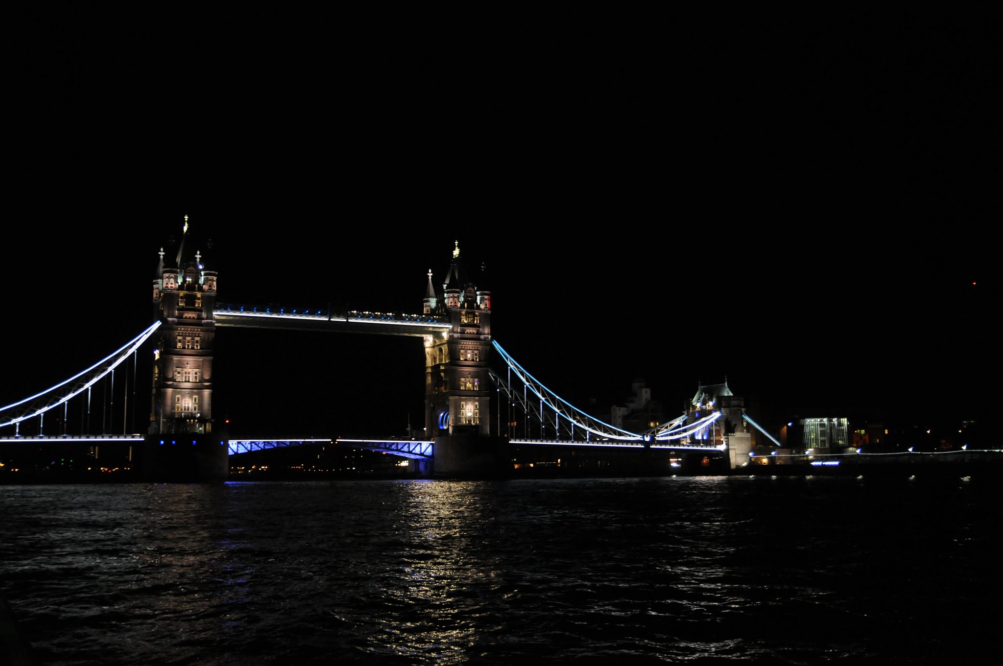 DSC_3645.JPG - Tower Bridge, zvedací most v Londýně nad řekou Temží. Ve druhé polovině 19. století se ve východní části Londýna začala rozmáhat průmyslová výstavba. V souvislosti s tím bylo nutné vybudovat nový most přes řeku, který by stál po proudu řeky za mostem London Bridge. Nebylo zde ale možné postavit tradiční typ mostu, protože by znemožnil lodní dopravu do Londýnského přístavu, který se nacházel mezi mostem London Bridge a Towerem. Tunel pod Temží (tzv. Tower Subway) byl sice otevřen roku 1870, ale byl určen pouze pro osobní dopravu a po přerušení provozu tamní železnice pro pěší.