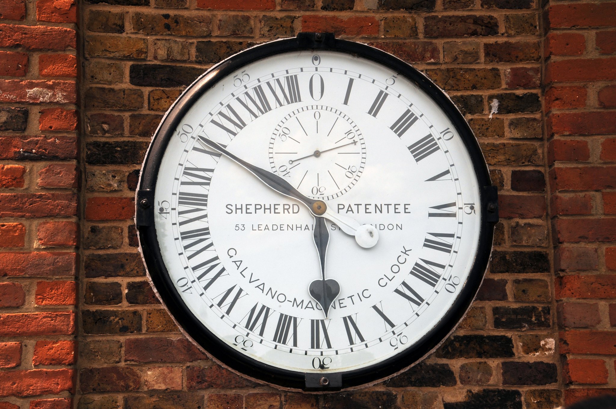 DSC_4084_1.jpg - Toto jsou jedny z první elektricky poháněných veřejných hodin, které byly na tomto místě instalovány v roce 1852. Číselník vždy zobrazuje Greenwichský hlavní čas (Greenwich Mean Time). Ten byl jedno období založen na měření času v této observatoři. Hodiny jsou ve 24 hodinovém formátu, kdy hodinová ručička je v pravé poledne v dolní části ciferníku na XII a o půlnosti nahoře. Hodiny ukazují přesný čas na 0,5 sekundy.