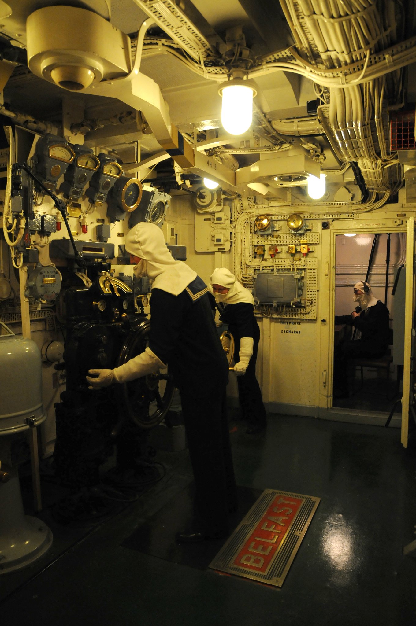 DSC_4676_1.jpg - Z toho prostoru byl HMS Befast řízen. Protor se nachází tři paluby dole a je chráněn vyšším obrněním. Kormidelník obdržel pokyny od důstojníka sedící v této místnosti (Officer of the Watch on the Compass Platform). Na druhé straně je pak lodní telefonní ústředna.