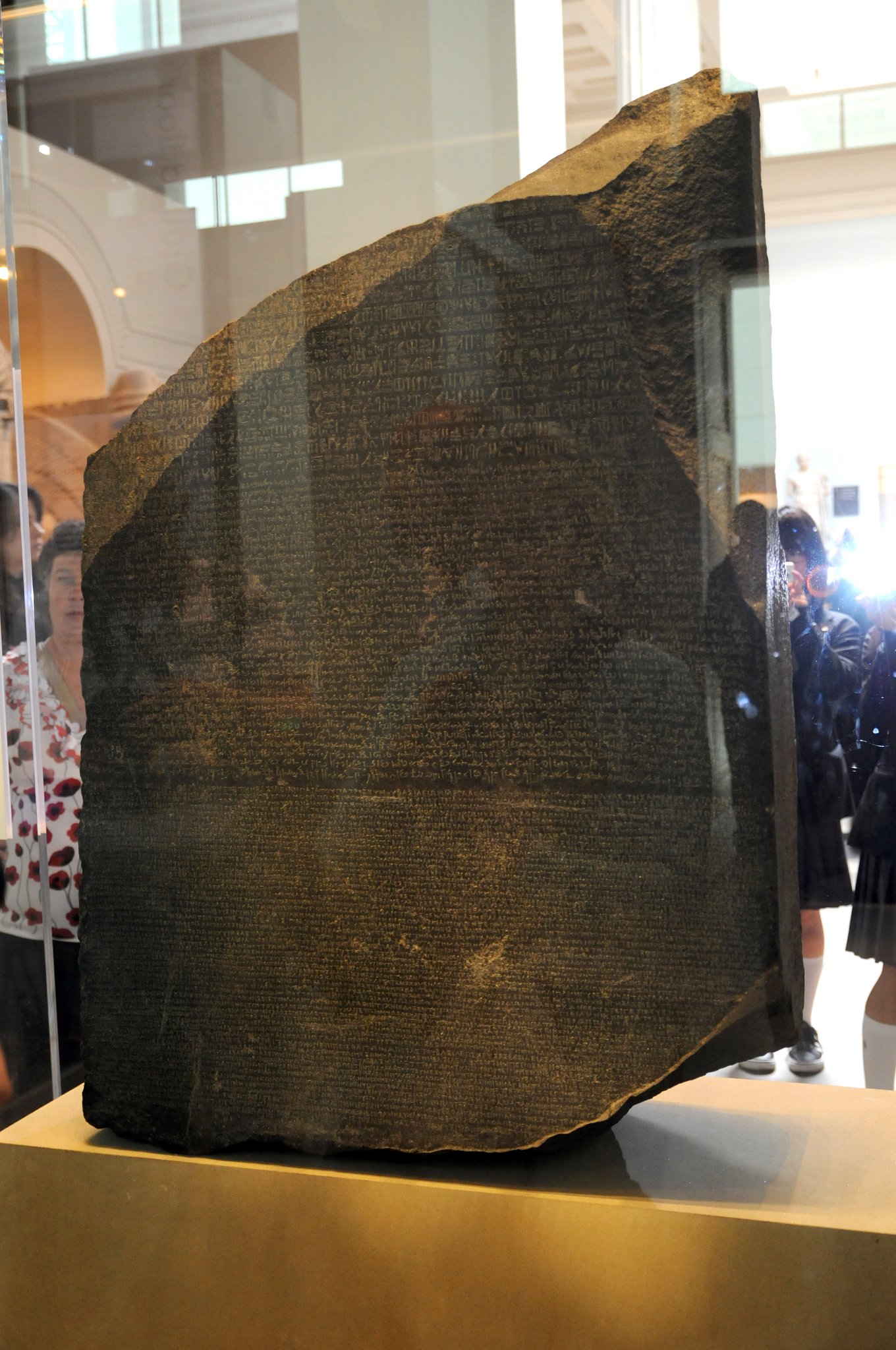DSC_5692_2.jpg - Rosettská deska (francouzsky: la pierre de Rosette) podle města Rosetta (arabsky: ar-Rašíd) při ústí Nilu, je tradiční označení černé žulové stély o výšce 114 cm a šířce 71 cm, na níž je ve 166 znacích zaznamenán text ve třech shodných verzích: dvou egyptských (v hieroglyfickém a démotickém písmu) a jednom řeckém překladu. Konfrontace řeckého překladu s do té doby nečitelným hieroglyfickým textem umožnila rozluštění hieroglyfů.Desku našel 15. července 1799 francouzský důstojník dělostřelectva Pierre-François-Xavier Bouchard při opevňovacích pracích u pevnosti Fort Jullien v rámci Napoleonova tažení do Egypta. Je do ní vytesán nápis kněze děkujícího roku 196 př. n. l. králi Ptolemaiovi V. Epifanovi ve třech shodných verzích - dvou egyptských (v hieroglyfickém a démotickém písmu) a jednom řeckém překladu. Jde vlastně o „kopii“ dekretu, kterým synoda zahrnula panovníka poctami v devátém roce jeho panování. V té době byla v Egyptě úředním jazykem řečtina.
