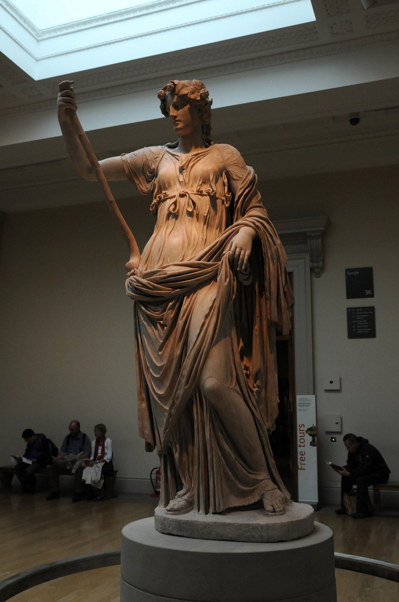 DSC_5775_2.jpg - V antické mytologii, Thalia byla jednou z devíti Múz. Múzy byly společníce boha Apollóna a věnovaly se umění a vědám. Ačkoli Thalia byl spojována s komedií, Římští básníci ji popisují jjako půvabnou a něžnou. Tato umně vyřezávaná mramorová socha krásně vystihuje jejího ducha.Věnec z břečťanu a pastýřská hůl symbolizují Thalii  v souvislosti s krajinou, ze které pochází komické vystoupení. Její těžký plášť ji sklouzl z ramen, odhaluje tenčí nedostatečné oblečení, který zvýrazňuje její svůdné ženské tělo.Socha byla objevena v roce 1776 britským malíř Gavinem Hamiltonem. S řadou dalších soch ve starobylé budově lázní přístavního města Říma, Ostia. V souladu s praxí v té době, byla socha odborně zrestaurována a pak ji získal přední britský sběratel, Charles Townley, pro  muzeum v Londýně.