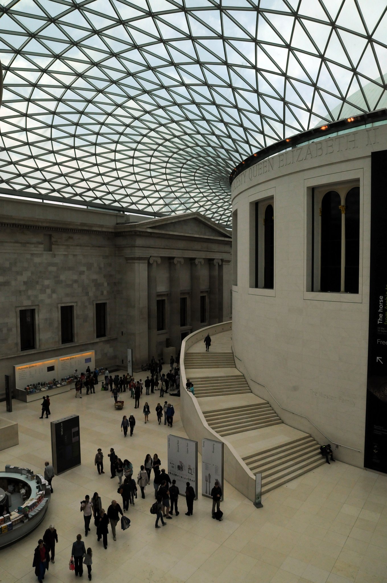 DSC_5780_1.jpg - Velká dvorana Alžběty II. je zastřešená plocha v centru budovy muzea, navržená společností Foster and Partners. Byla otevřena v prosinci 2000 a je největším zastřešeným prostorem v Evropě. Střecha je tvořena kovovou konstrukcí vyplněnou 1 656 skleněných panelů. V centru velké dvorany se nachází čítárna uvolněná Britskou knihovnou, která její funkci zabezpečuje v St Pancras.