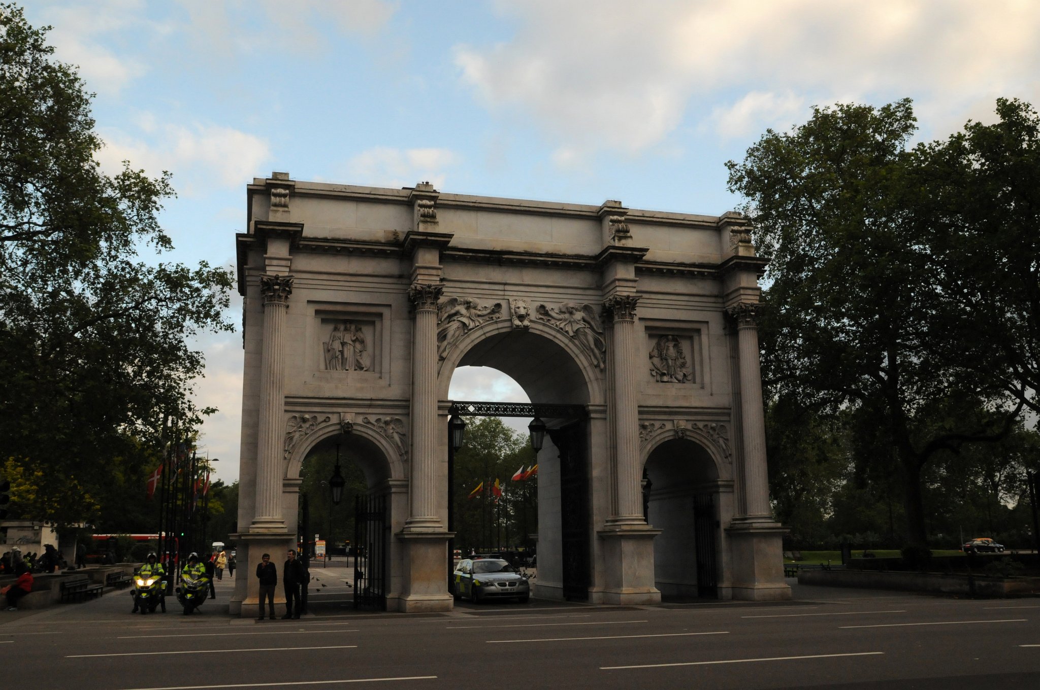 DSC_6196_1.jpg - Mramorový oblouk (Marble Arch) je oblouk z kararskéko mramoru poblíž Speakers' Corner v Londýnském Hyde Parku v městském obvodu Westminster u západního konce Oxford Street.Autorem návrhu byl v roce 1828 John Nash. Inspiroval se triumfálním Konstantinovým obloukem v Římě. Původně byl vztyčen na ulici Mall jako brána do Buckinghamského paláce (Nash původní Buckingham House rozšířil na královský palác pro Jiřího IV. ).Poté, co byl shledán příliš úzkým pro královský kočár, byl roku 1851 přemístěn na místo kde stojí dodnes. Uvnitř oblouku se nacházejí tři malé místnosti, které byly do roku 1950 používány jako policejní stanice. Některé sochy určené pro jeho výzdobu, především ty, které měly zdobit původní hlavní vstup, byly umístěny na průčelí Národní galerie. Oblouk stál poblíž tyburnského popraviště, místa veřejných poprav v období let 1388 až 1793. Průchod nebo průjezd obloukem je povolen pouze členům královské rodiny a příslušníkům královského jízdního dělostřelectva. Zajímavé, tka co tam dělají ti policajti?