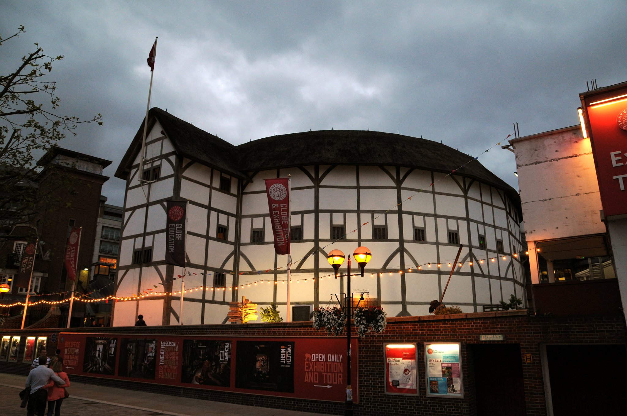 DSC_7674_1.jpg - Replika divadla Globe v Southwarku. Divadlo Globe je spjaté s osobou Williama Shakespeara. William Shakespeare byl členem a podílníkem divadelní společnosti nazývané Služebníci lorda komořího. Svá představení hráli v Divadle Jamese Burbage. Roku 1597 jim však nájem na divadlo vypršel, což znamenalo velké potíže. Bylo třeba něco podniknout. Divadelní společnost se rozhodla ukrást své vlastní divadlo na základě prošlé smlouvy, kde se psalo, že pokud budou chtít, mohou divadlo rozebrat. Divadlo přesunuli na jižní břeh řeky Temže a pojmenovali ho Globe. Byl to vynikající tah, Služebníci lorda komořího zachránili své divadlo i své kariéry. Jednu chybu však udělali, střechu nového divadla vyrobili z hořlavých došků. V létě roku 1613 Globe do základů vyhořel. Oheň způsobilo dělo, ze kterého vystřelili při představení. Dělo se nestrefilo a zapálilo doškovou střechu. Podílníci měli povinnost postavit nové divadlo. Tato verze Globu přežila 30 let, dokud nebylo divadlo z nařízení puritána Olivera Cromwella uzavřeno. Samotná budova byla v roce 1644 stržena.Ke konci 20. století byl po přestávce trvající 350 let postaven další Globe. Americký herec a Shakespearův milovník Sam Wanamaker (otec Zoë Wanamakerové) se rozhodl, že v Bankside postaví přesnou repliku Globu. Teď zde stojí divadlo tak, jak vypadalo za Shakespearových časů. V Globu probíhá každoročně letní sezona Shakespearových her a také je zde největší trvalá Shakespearova výstava na světě.