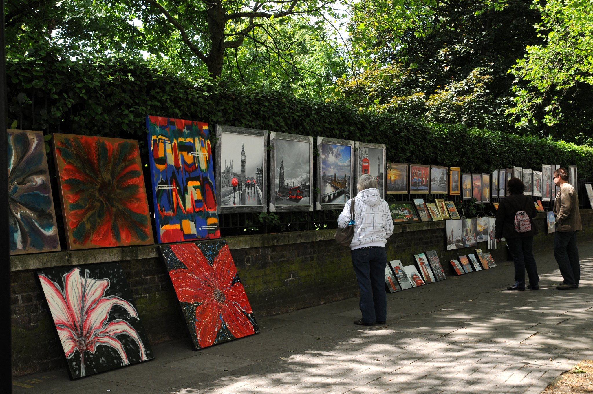 DSC_7927_1.jpg - Prodejci o brazů na hranici Hyde Parku. Hyde Park je jeden z největších parků v centru Londýna v obvodu Westminster a jeden z královských parků v Londýně. Park je rozdělen Serpentinovým jezerem na dvě poloviny. Hyde Park sousedí s Kensingtonskými zahradami, které jsou často považovány za součást Hyde Parku. Hranici mezi oběma parky tvoří West Carriage Drive. Plocha Hyde Parku činí 1,4 km² a Kensingtonských zahrad 1,1 km².