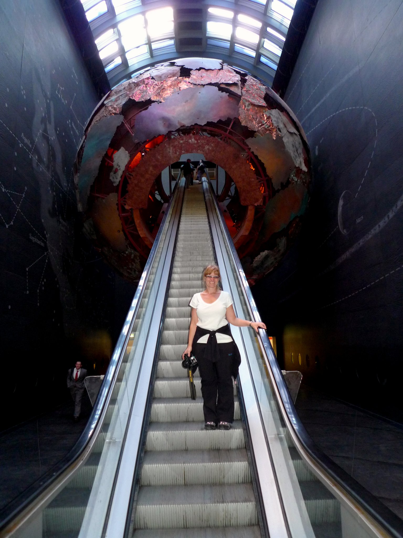 P1070472_1.jpg - Janina na eskalátoru směřujícím do zeměkoule v Přírodopisném muzeu v Londýně. Vstup do Earth Galleries projektoval Neal Potter.