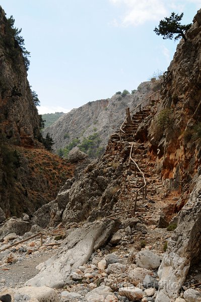 DSC_8859_2.jpg - Po asi jednom až dvou kilometrech se stezka na dně soutěsky mění  ve schody vytesané do skály, chatrné zábradlí alespoň malinko zvyšuje bezpečnost při stoupání vzhůru po skále.