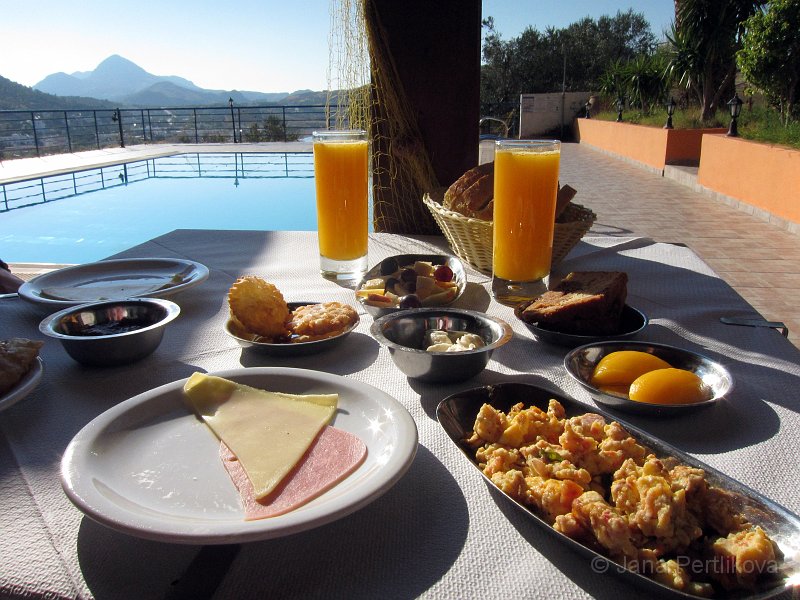 IMG_1207_2.jpg - Ubytovaní jsme v Panorama Studio manželů Baradakis. Naše první snídaně servírovaná u bazénu s výhledem na hory a moře byla vydatná. Stejně jako všechny následující snídaně.