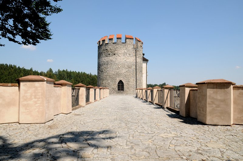 DSC_3432_1.jpg - Válcová věž solitérně stojící před jižním čelem hradního jádra, střežící jižní bránu dostupnou po kamenném mostě zřízeném v roce 1829 přes šíjový příkop.
