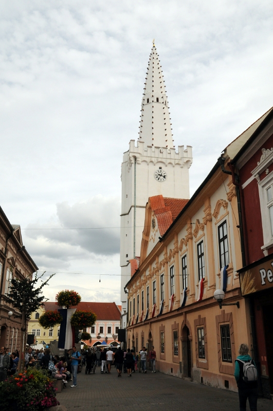 DSC_9625_1.jpg - Radniční věž v Kadani. Jedná se o bílou gotickou věž, která dosahuje výšky 53,7 metrů.lupaVěž vznikla před rokem 1402, kdy je poprvé zmíněná arkýřová kaple, kterou můžeme dodnes spatřit v prvním patře věže. Na začátku 16. století věž upravil a dostavěl Petr Hündl. Dodnes můžeme na vrcholu věže spatřit podpis autora v podobě sochy psa.