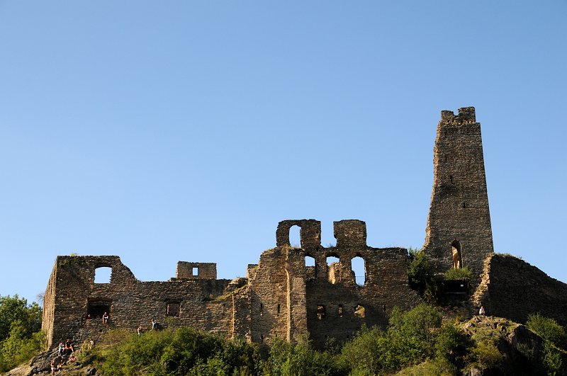 DSC_1700_1.jpg - Zachované zříceniny hradu Okoře jsou rozsáhlé. Z dolního hradu, vybudovaného koncem 15. století, zůstala sice jen část zdiva opevnění, bašta a nepatrné zbytky první brány, zato z nejstarší části, tzv. horního hradu, dosud stojí obvodové zdivo refektáře, zřízeného koncem 15. století, přízemí brány na druhém nádvoří a zejména východní část bývalé pětipatrové hranolové věže se zbytky gotické kaple v přízemí. Zachovaly se také části obou paláců, obdélných staveb původně dvoupatrových, i zasypaná studně.