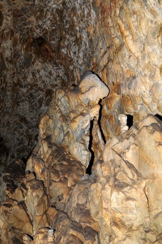 DSC_9853_1.jpg - „Čarodějnice“ v tzv. Nové jeskyni. Je to hranatý vzpříčený vápencový balvan, odloupnutý se stropu a obrostlý v nejvyšší části kaskádovým sintrem v podobě ruky a hlavy, zahalené šátkem.