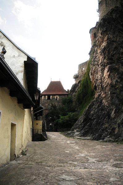 DSC_7942_1.jpg - Když vcházíte na nádvoří, nelze si nevšimnout vysoké čedičové skály, na které se hrad vypíná. Do černého kamene je zapuštěno šest dělových koulí, kterými v roce 1757 Střekov ostřelovalo chorvatské vojsko generála Laudona. Povídá se, že pokud najdete místo, ze kterého jsou vidět všechny střely najednou, splní se vám nejtoužebnější přání.
